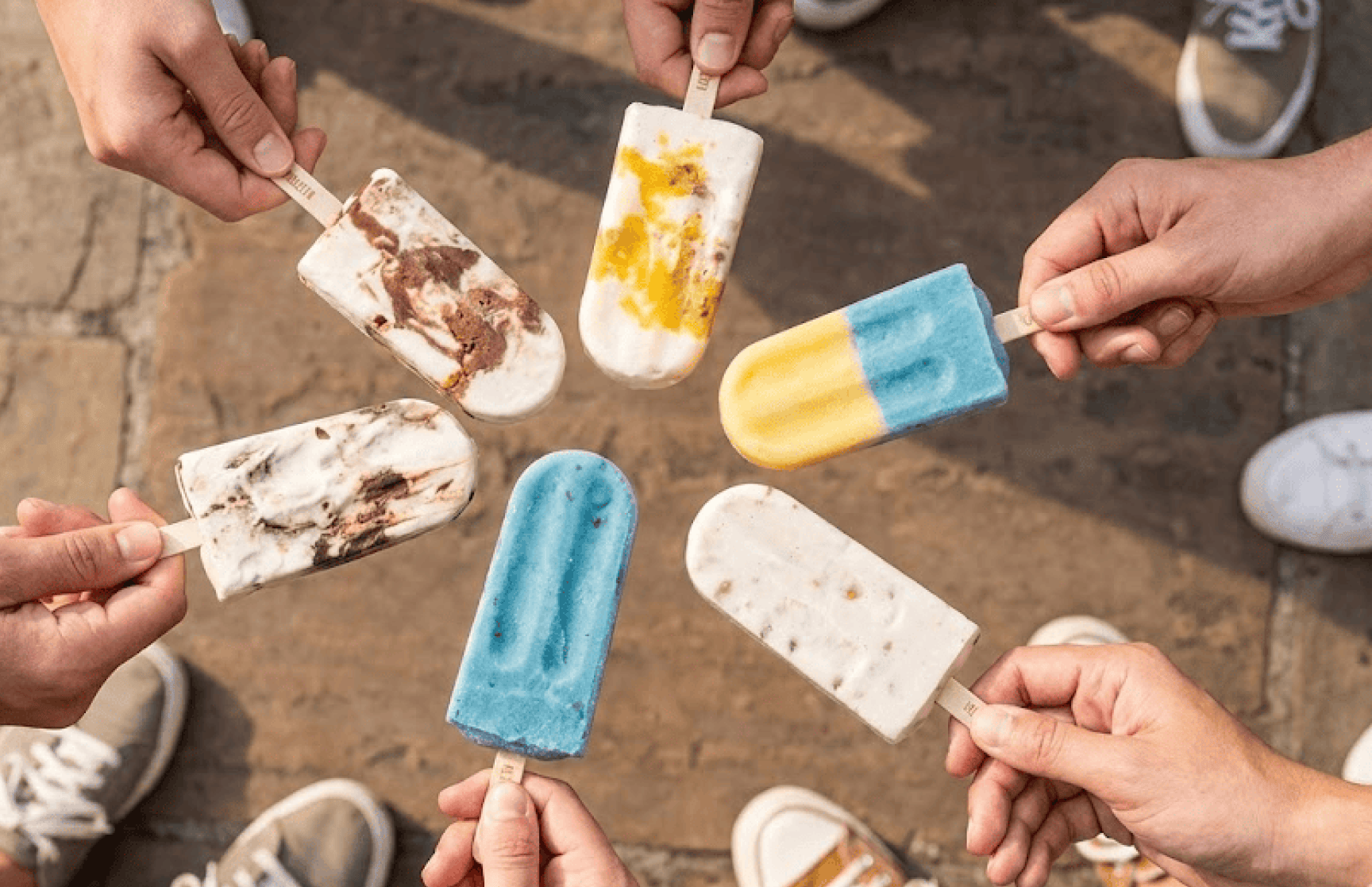 Friends holding La Paleta popsicles